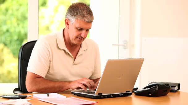 Muž psát něco na jeho laptopu a pózování — Stock video