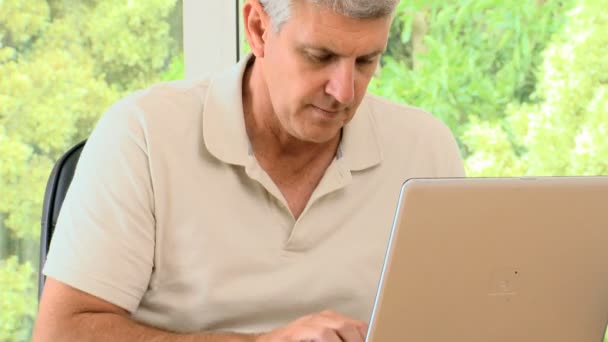 Mature man working on his laptop and then posing — Stock Video