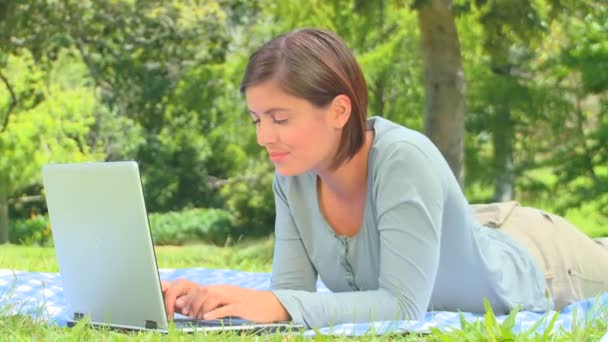 Молодая женщина болтает на своем ноутбуке — стоковое видео