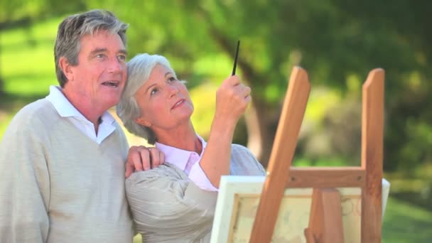 Ouder paar kijken naar een schilderij — Stockvideo