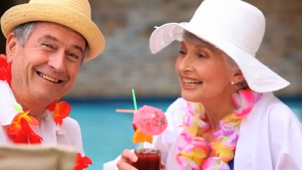 Senior couple with garlands drinking colored cocktails — Stock Video