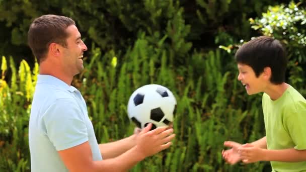 Père apprenant à son fils à diriger un football — Video