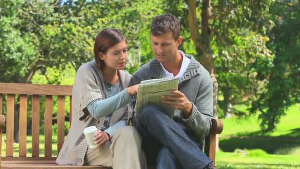 Pareja joven haciendo un crucigrama — Vídeos de Stock