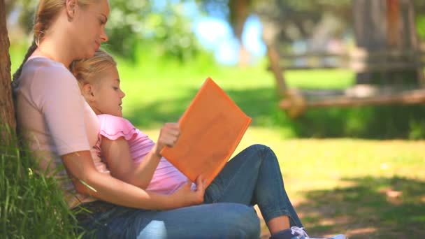 Jong meisje en haar moeder lezen van een boek — Stockvideo