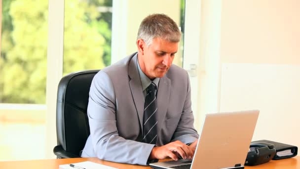 Mature man in suit working on a laptop and posing — Stock Video