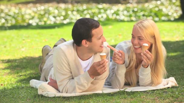 Pareja joven comiendo helado y riendo — Vídeo de stock