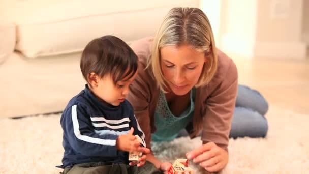 Dziecko grając z matką na dywanie — Wideo stockowe