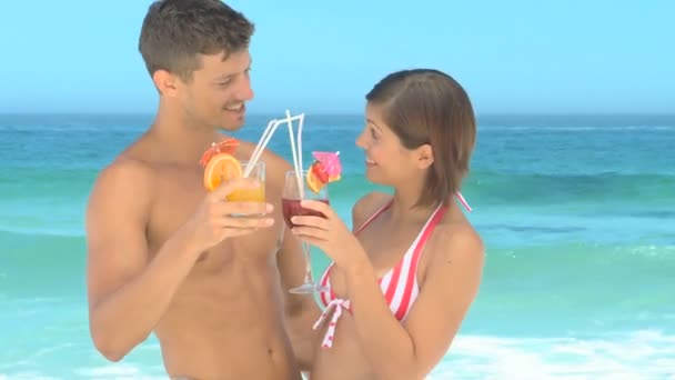 Niedliches Paar trinkt Cocktails am Strand — Stockvideo