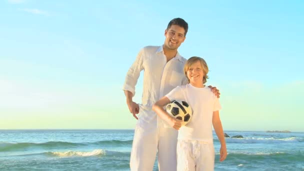 Vader en zoon poseren op een strand — Stockvideo