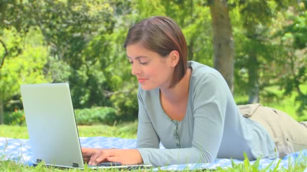 Jeune femme surfant sur son ordinateur portable en plein air — Video