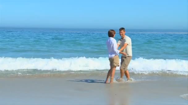 Dulce pareja jugando en el borde del agua — Vídeos de Stock