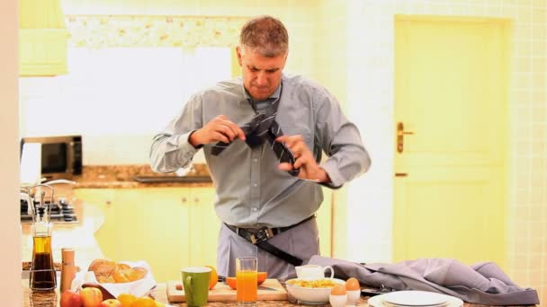 Uomo che cerca di vestirsi mentre mangia e riceve una chiamata — Video Stock