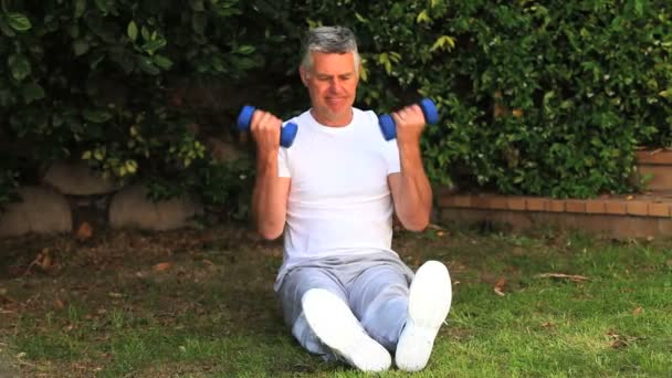 Hombre ejercitando sus brazos usando pesas — Vídeos de Stock