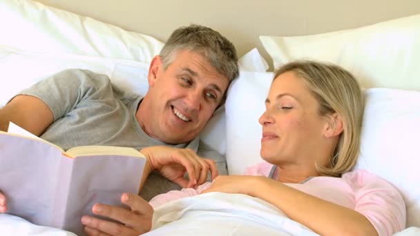 Casal lendo um livro na cama — Vídeo de Stock