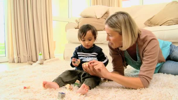 Jonge moeder spelen met baby op tapijt — Stockvideo