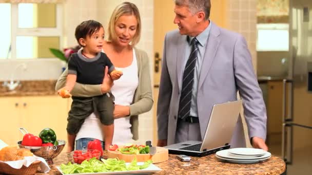 Pareja en cocina con bebé y portátil — Vídeo de stock