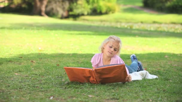 Chica joven leyendo un libro — Vídeo de stock