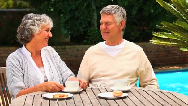 Couple assis bavardant autour d'un café près d'une piscine — Video