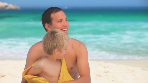 Uomo che tiene in braccio suo figlio dopo una nuotata — Video Stock