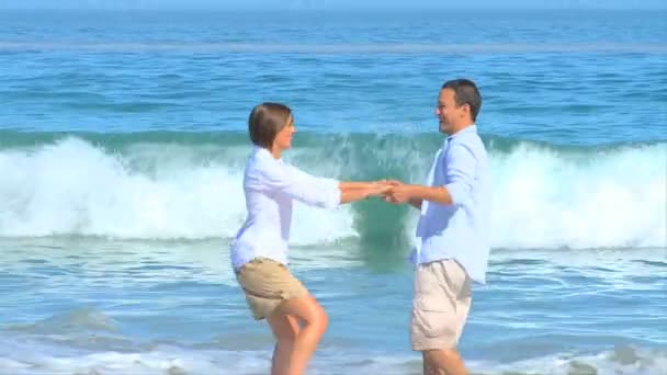 Sweet couple playing at the edge of the water — Stock Video