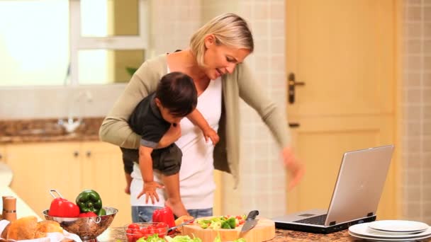 Mujer ocupada llamando y tratando con su bebé y su computadora portátil — Vídeo de stock