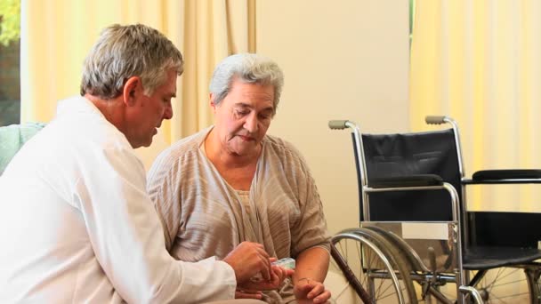 Doctor explaining her medication to a mature patient — Stock Video