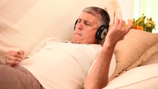 Hombre escuchando música con auriculares — Vídeo de stock