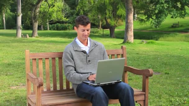 Joven hombre charlando en su computadora portátil — Vídeos de Stock