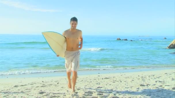 Красавчик бегает со своей доской для серфинга — стоковое видео