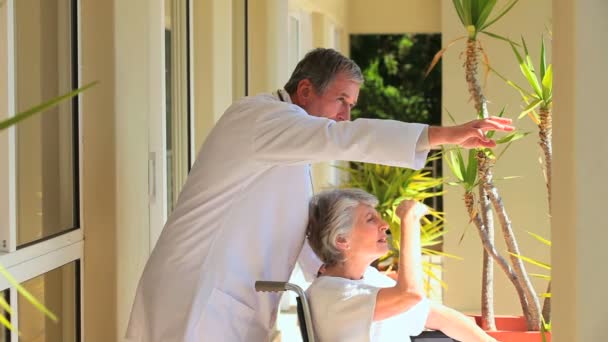 Lady in a wheelchair with her doctor — Stock Video