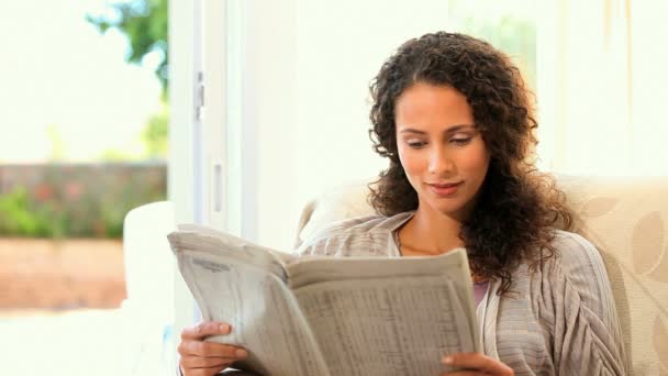 Young woman reading a newspaper — Stock Video