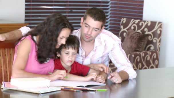 Padres ayudando a su hijo con la tarea — Vídeo de stock