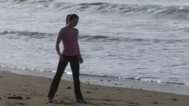 Женщина растягивается на пляже — стоковое видео