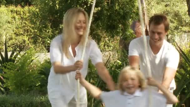 Parents help their son on a swing — Stock Video