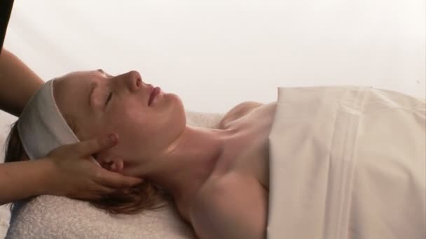 Una mujer recibiendo un masaje facial — Vídeo de stock