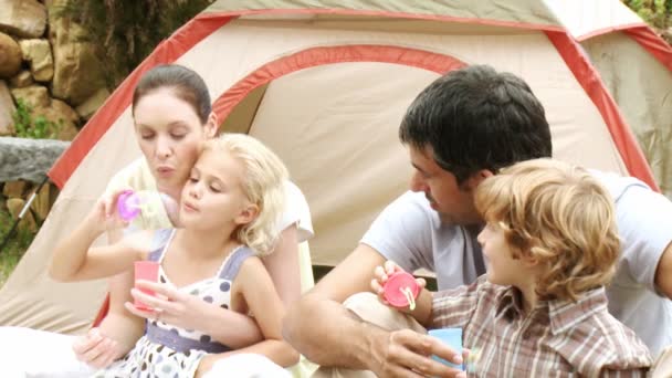 Los padres con sus hijos en el jardín soplando burbujas — Vídeo de stock
