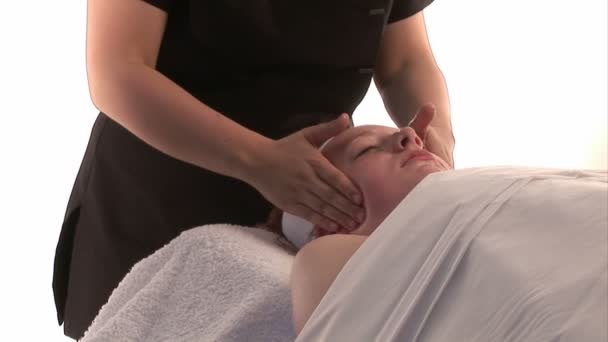 Una mujer recibiendo un masaje facial — Vídeo de stock