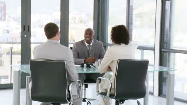 Três pessoas bem sucedidas falando sobre negócios em uma mesa — Vídeo de Stock