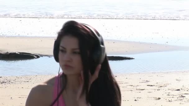 Vrouw op strand luisteren naar muziek — Stockvideo