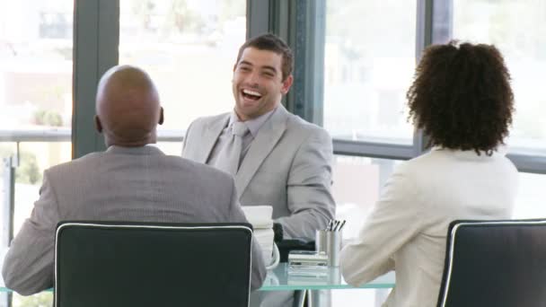 Three smart businesspeople laughing in a meeting — Stock Video
