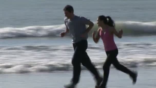 Iki kişi bir plaj boyunca koşu — Stok video