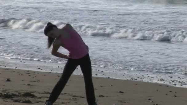 Vrouw die zich uitstrekt op strand — Stockvideo