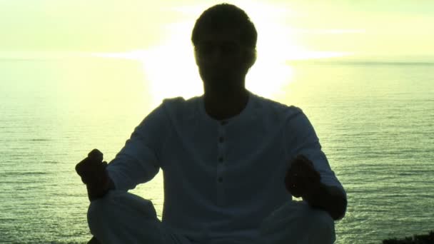 Hombre practicando Yoga junto al océano — Vídeo de stock