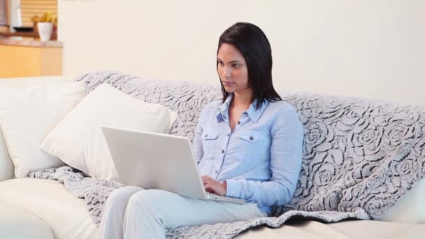 Mulher usando um laptop enquanto está sentado — Vídeo de Stock