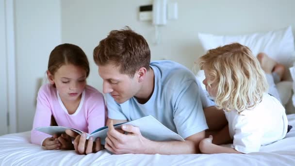Vater liest mit seinen Kindern ein Buch — Stockvideo
