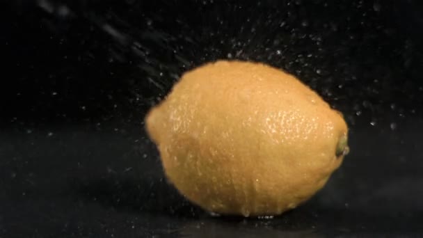 Вода розбризкується на лимоні в дуже повільному русі — стокове відео