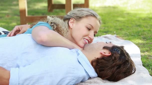 Un couple souriant couché ensemble sur le sol alors qu'ils regardent la caméra — Video