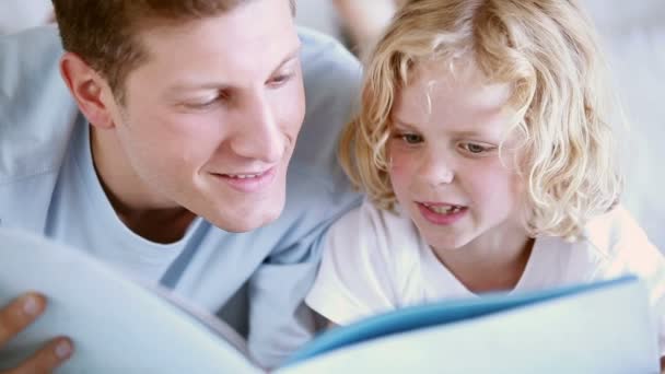 Niño leyendo un libro en voz alta con su padre — Vídeos de Stock