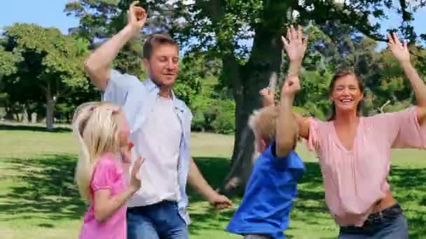 Сім'я захоплено стрибає в парку — стокове відео