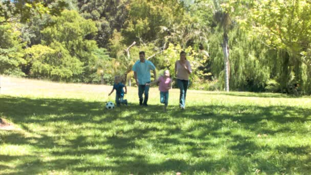 Familia en cámara lenta corriendo con una pelota de fútbol — Vídeo de stock